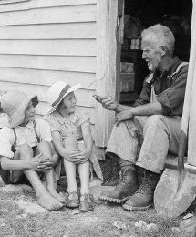 An unidentified man talking to two small children, in the entrance to a hut, West Coast Region. Williams, Edgar Richard, 1891-1983 :Negatives, lantern slides, stereographs, colour transparencies, monochrome prints, photographic ephemera. Ref: 1/4-101013-F. Alexander Turnbull Library, Wellington, New Zealand. http://natlib.govt.nz/records/32049331